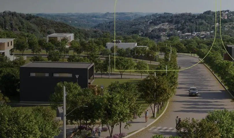 Rua arborizada do loteamento Marco Norte, com passeio, ciclistas e casas ao fundo